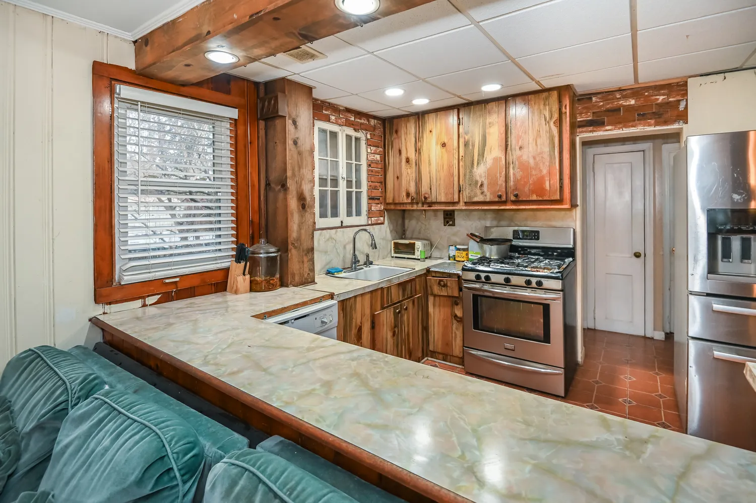 a kitchen with stainless steel appliances granite countertop a refrigerator a stove and a wooden floors