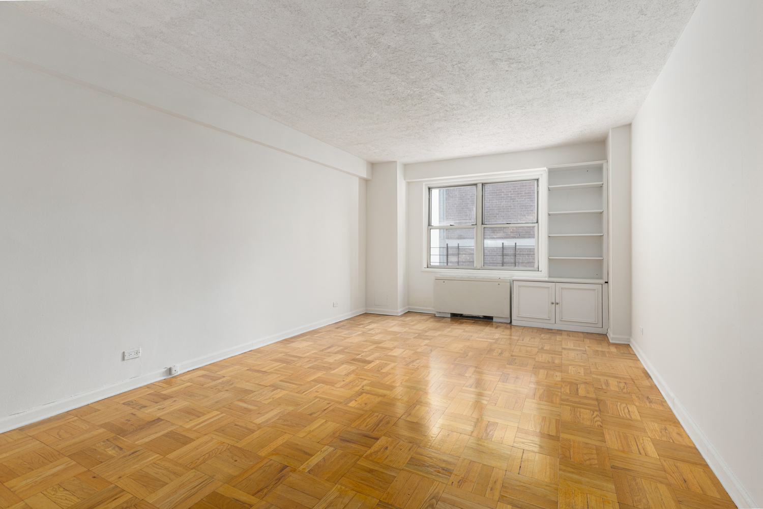 136 East 56th Street, Unit 9J Manhattan, NY 10022 - Photo 8 of 14 a view of an empty room with a window
