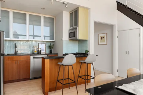 a kitchen with granite countertop chair and wooden floor
