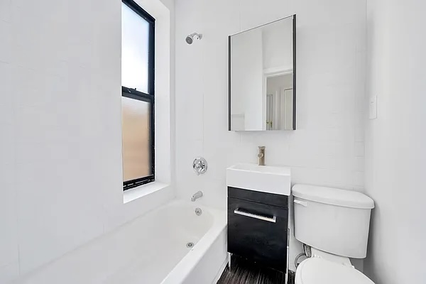66 West 138th Street, Unit 2C Manhattan, NY 10037 - Photo 4 of 5 a bathroom with a toilet a sink and bathtub