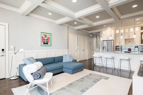 a living room with furniture and a dining table with wooden floor