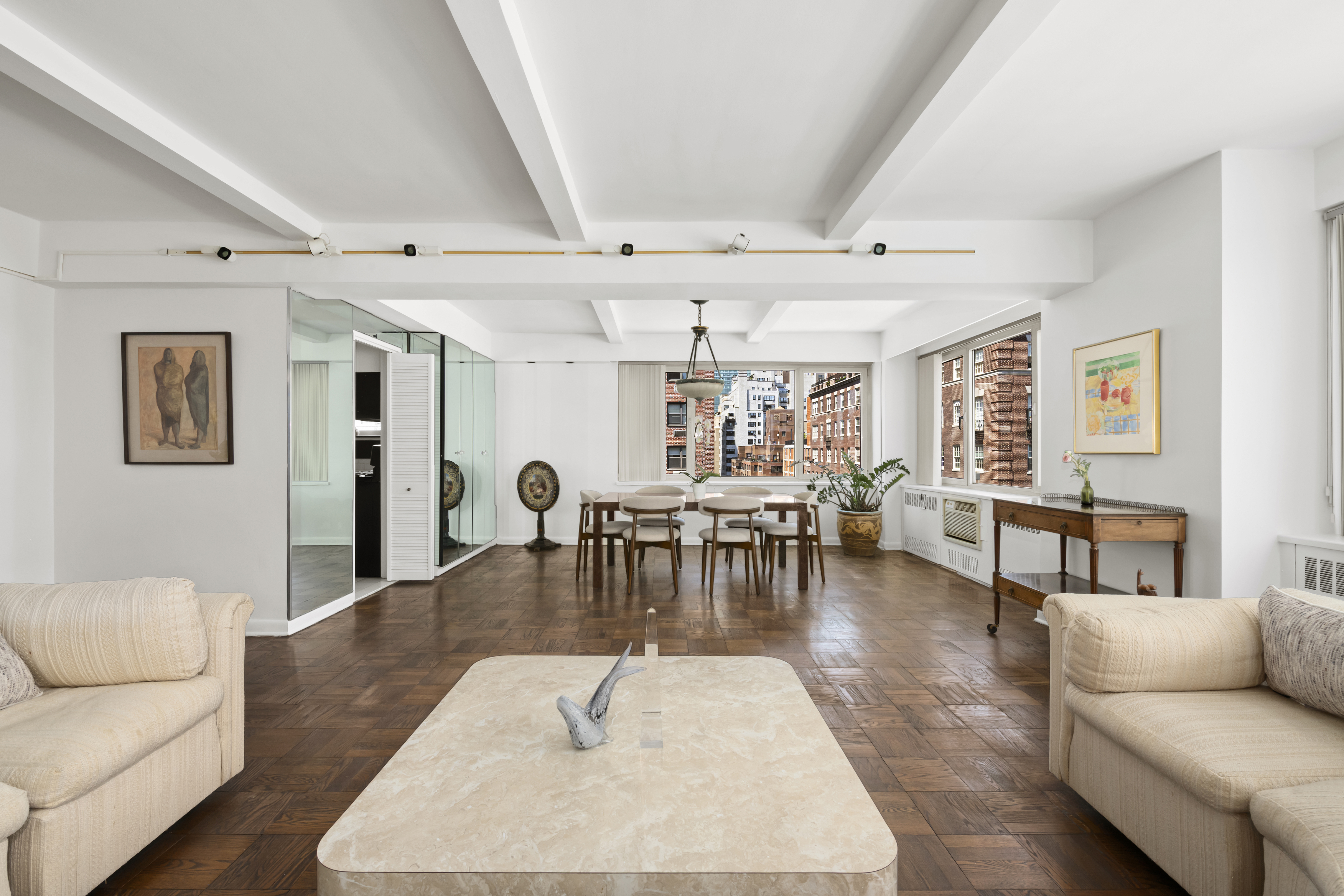 25 Sutton Place South, Unit 16B Manhattan, NY 10022 - Photo 3 of 16 a living room with furniture and wooden floor