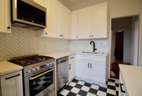 a kitchen with granite countertop a sink a stove and cabinets