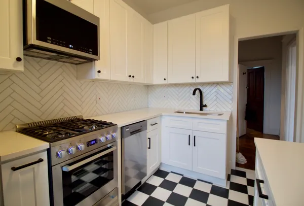 a kitchen with granite countertop a sink a stove and cabinets