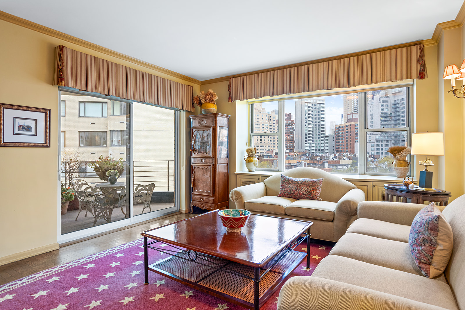 200 East End Avenue, Unit 10KL Manhattan, NY 10128 - Photo 2 of 23 a living room with furniture and a floor to ceiling window next to a large window