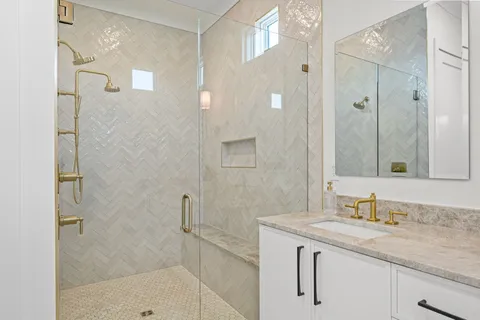 a bathroom with a granite countertop sink a mirror and a shower