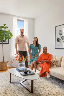 a living room with furniture a rug and a potted plant