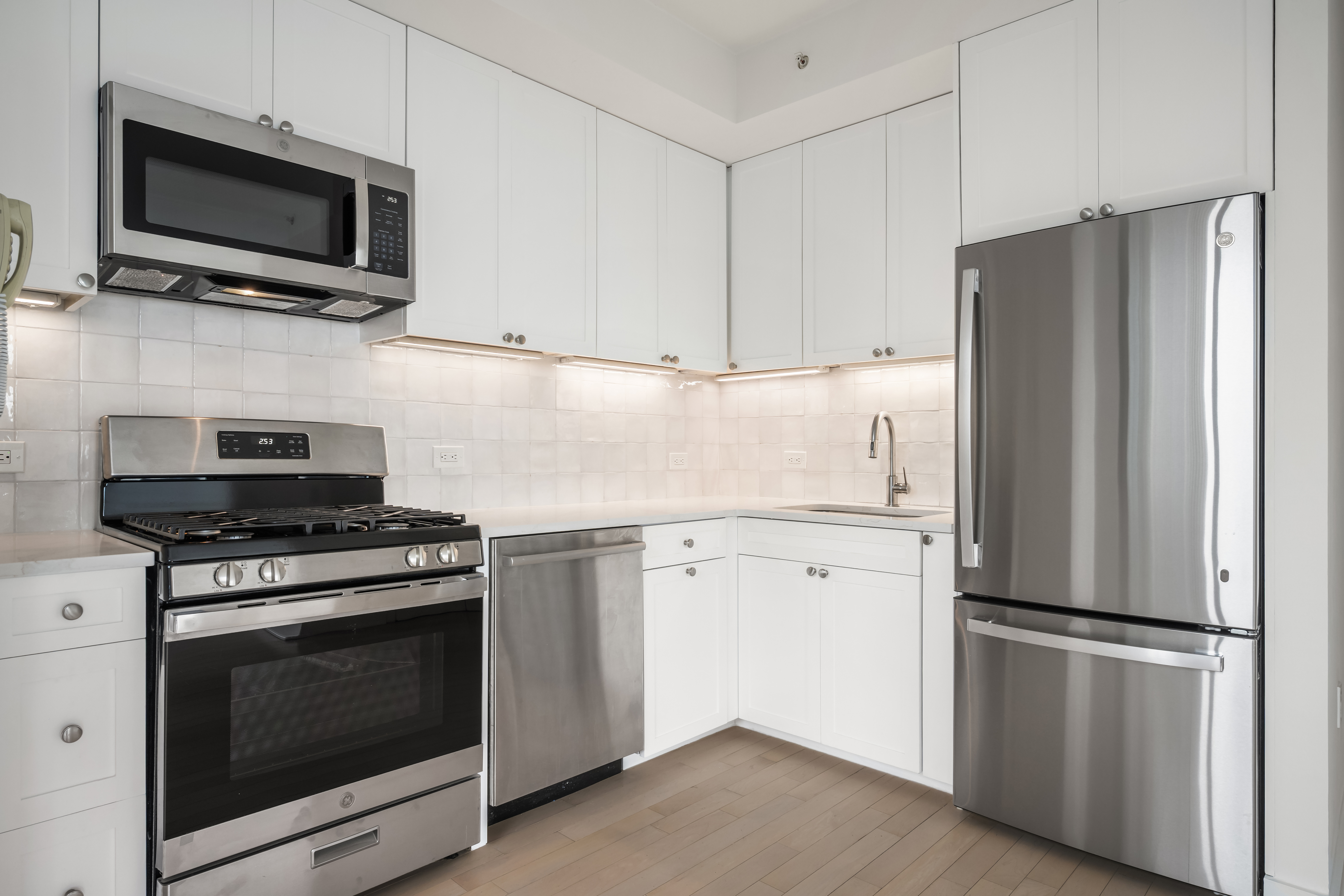 230 Ashland Place, Unit 19D Brooklyn, NY 11217 - Photo 2 of 11 a kitchen with cabinets stainless steel appliances and wooden floor