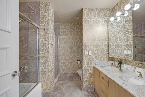 a bathroom with a granite countertop shower a sink and a mirror