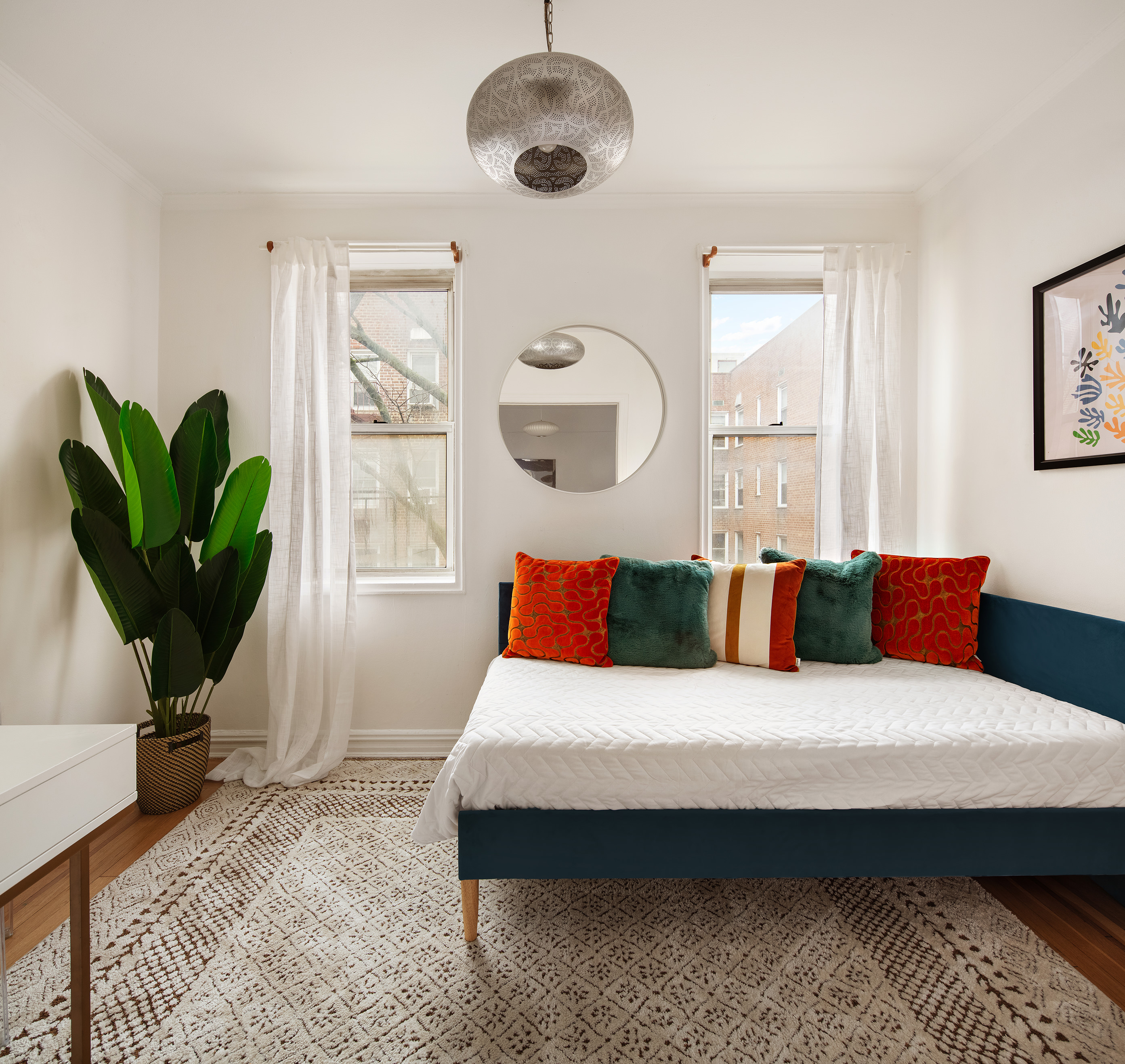 140 East 2nd Street, Unit 5F Brooklyn, NY 11218 - Photo 4 of 9 a bedroom with a bed a chandelier and next to a window