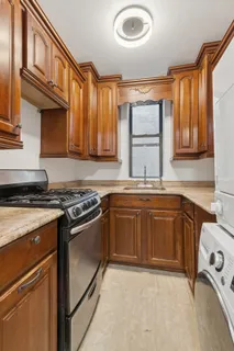 a kitchen with granite countertop a sink stove and cabinets