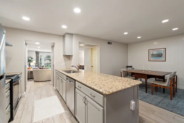a kitchen with a table chairs refrigerator and cabinets