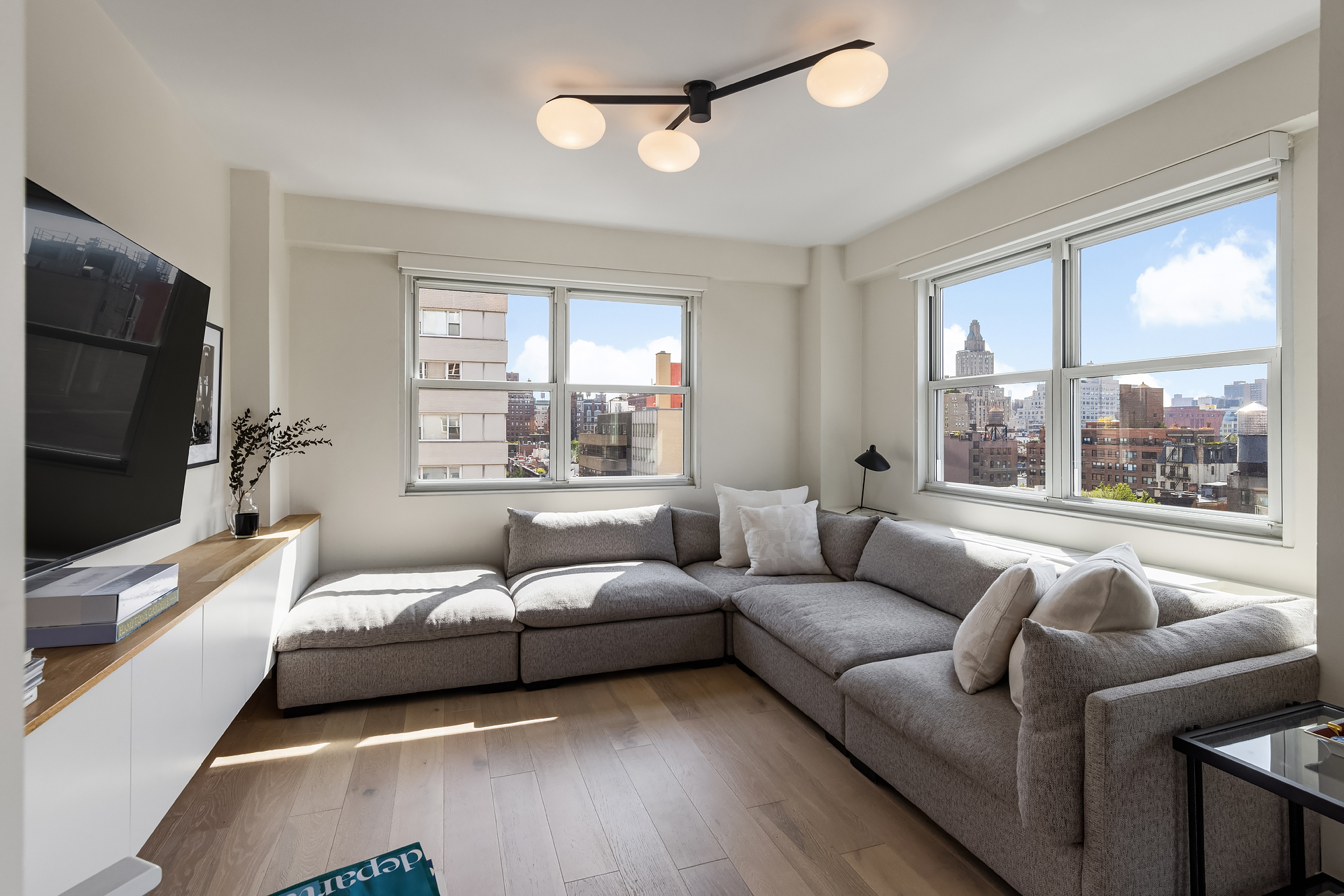 101 West 12th Street, Unit 12R Manhattan, NY 10011 - Photo 10 of 21 a living room with furniture flat screen tv and a large window