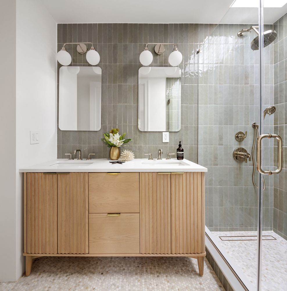 a bathroom with a double vanity sink mirror and shower