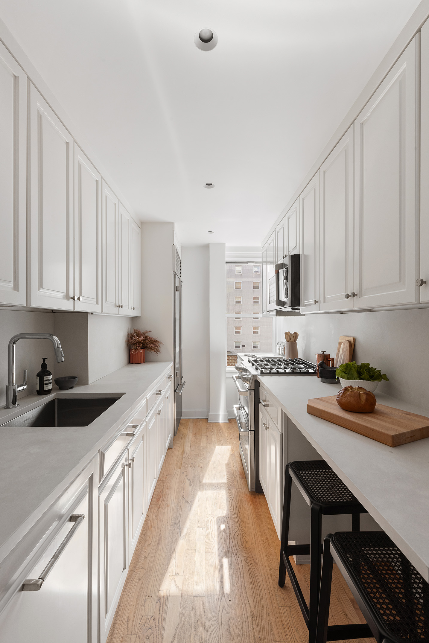 425 East 86th Street, Unit 11E Manhattan, NY 10028 - Photo 8 of 19 a kitchen with white cabinets stove and sink