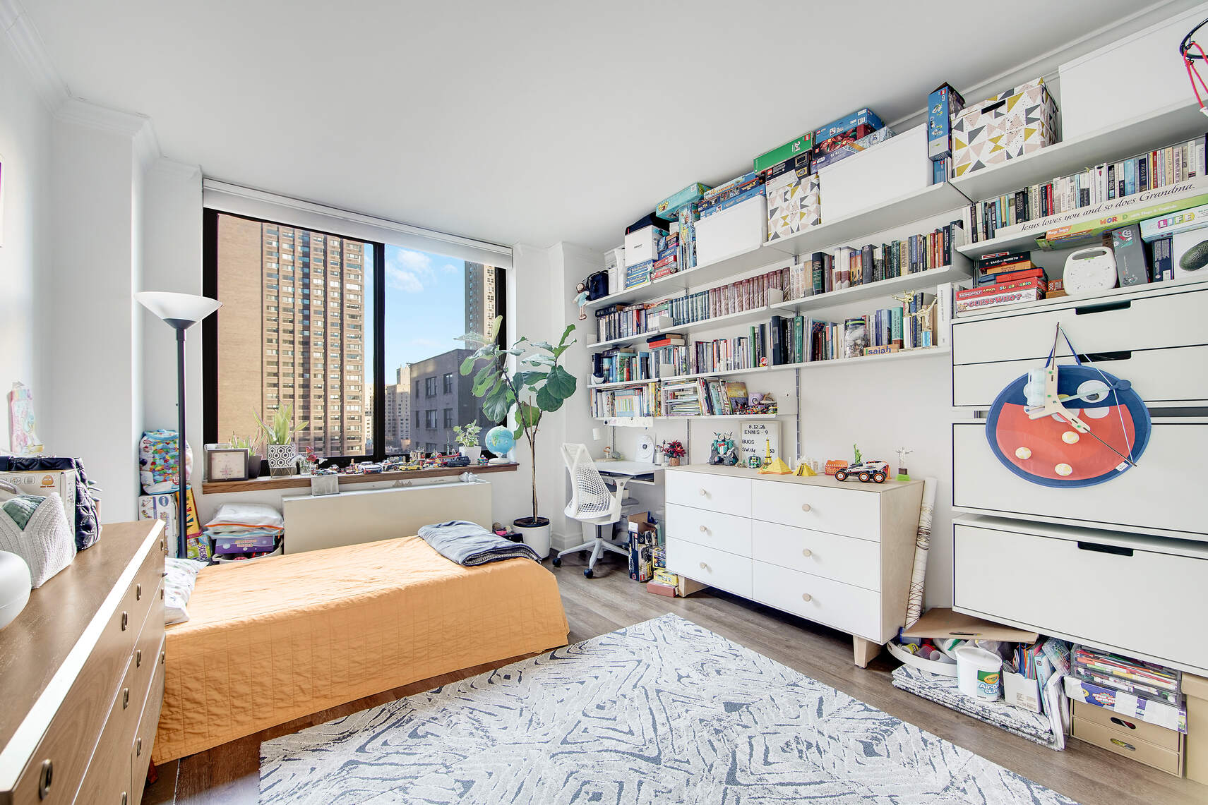 400 East 90th Street, Unit 9A Manhattan, NY 10128 - Photo 5 of 11 a bedroom with furniture and a book shelf