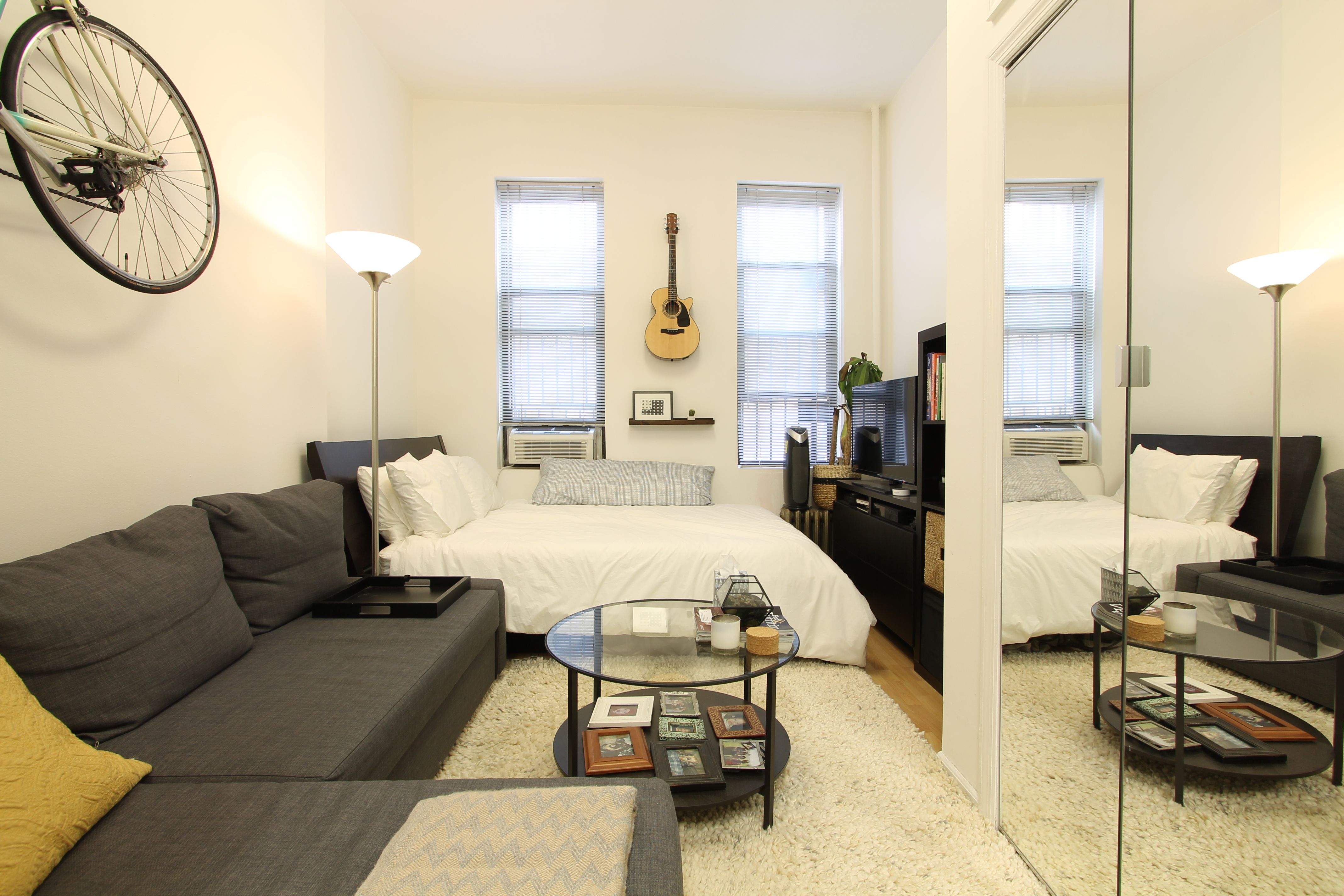 a living room with furniture a large window and a chandelier