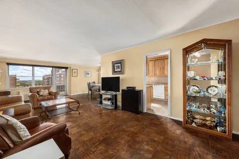 a living room with furniture a large window and a flat screen tv