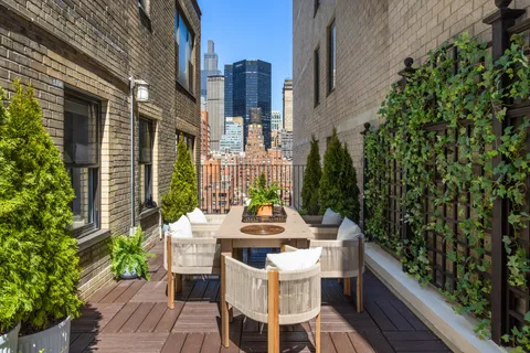 a view of a patio with a table and chairs and potted plants