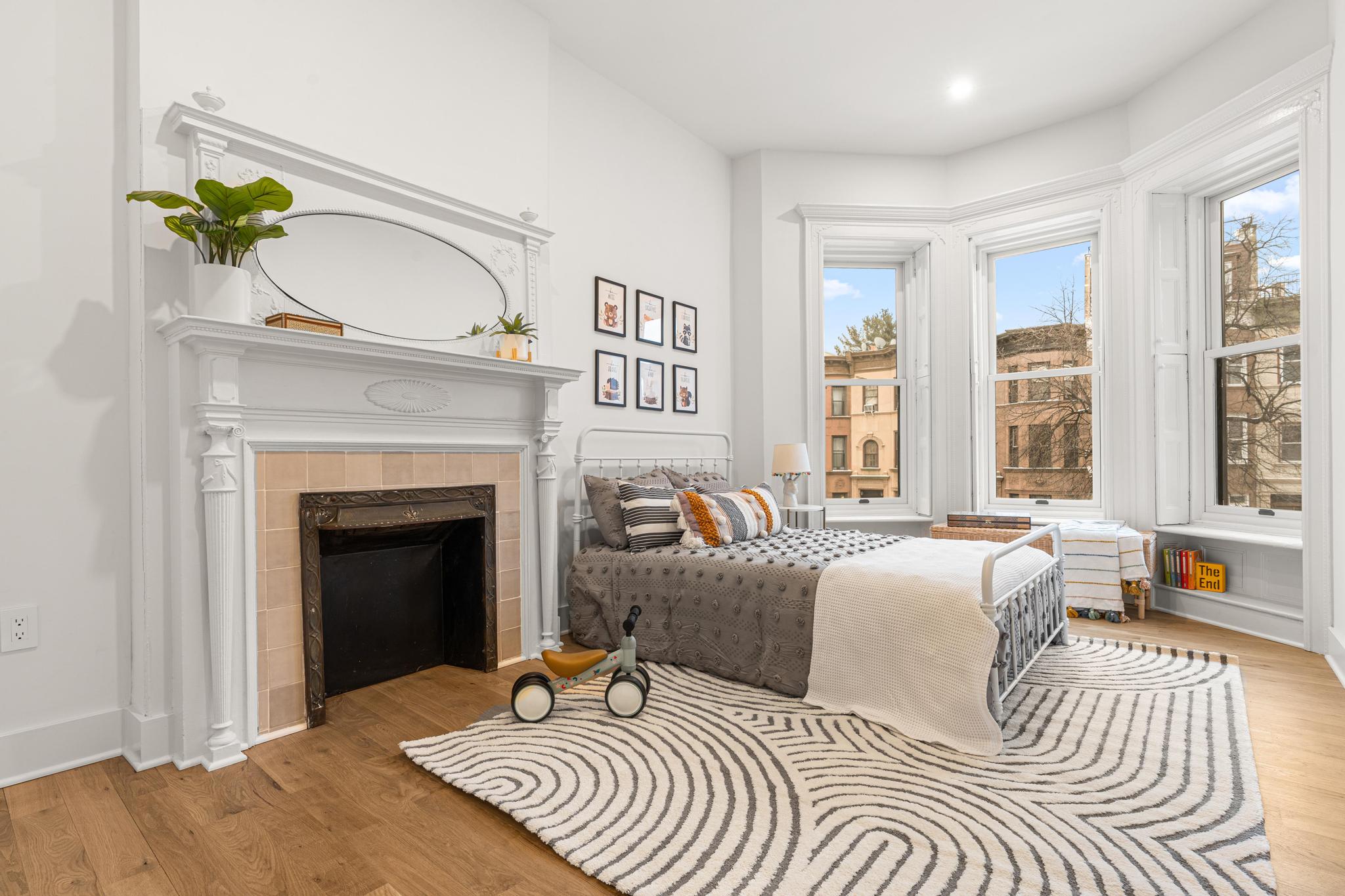 987 Sterling Place Brooklyn, NY 11213 - Photo 6 of 16 a bedroom with a bed and a fireplace