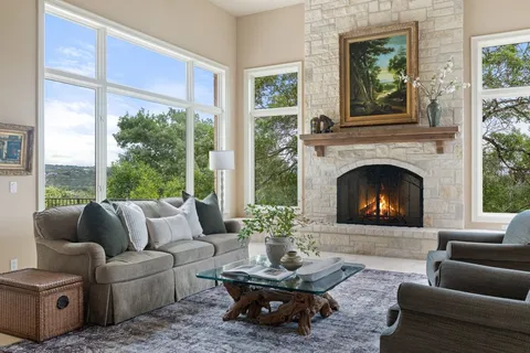 a living room with furniture large window and a fireplace
