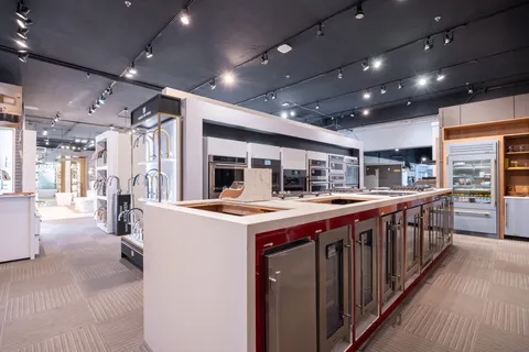 a kitchen with kitchen island a large counter top space and stainless steel appliances