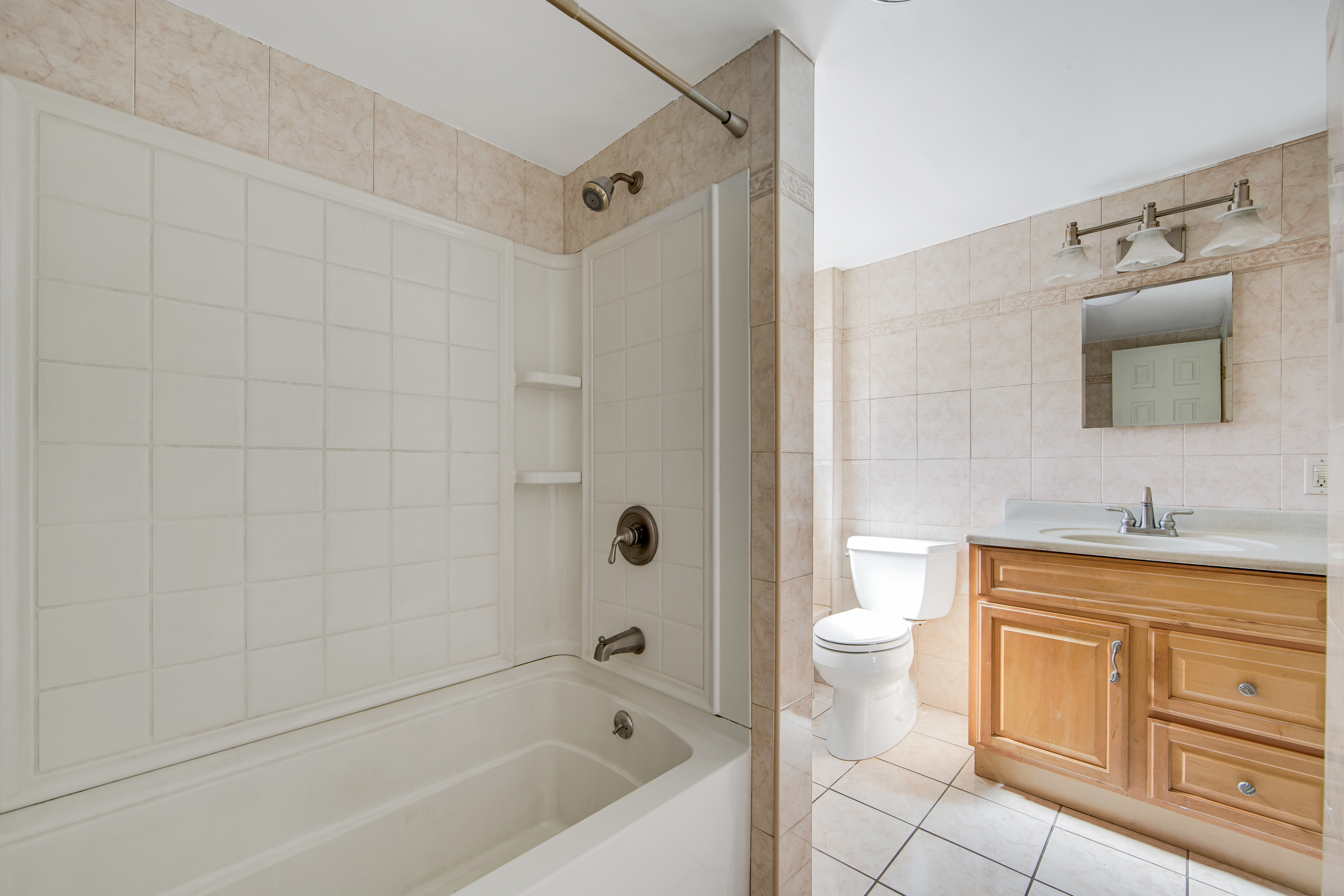 296 17th Street Brooklyn, NY 11215 - Photo 7 of 8 a bathroom with a bathtub shower sink vanity and toilet