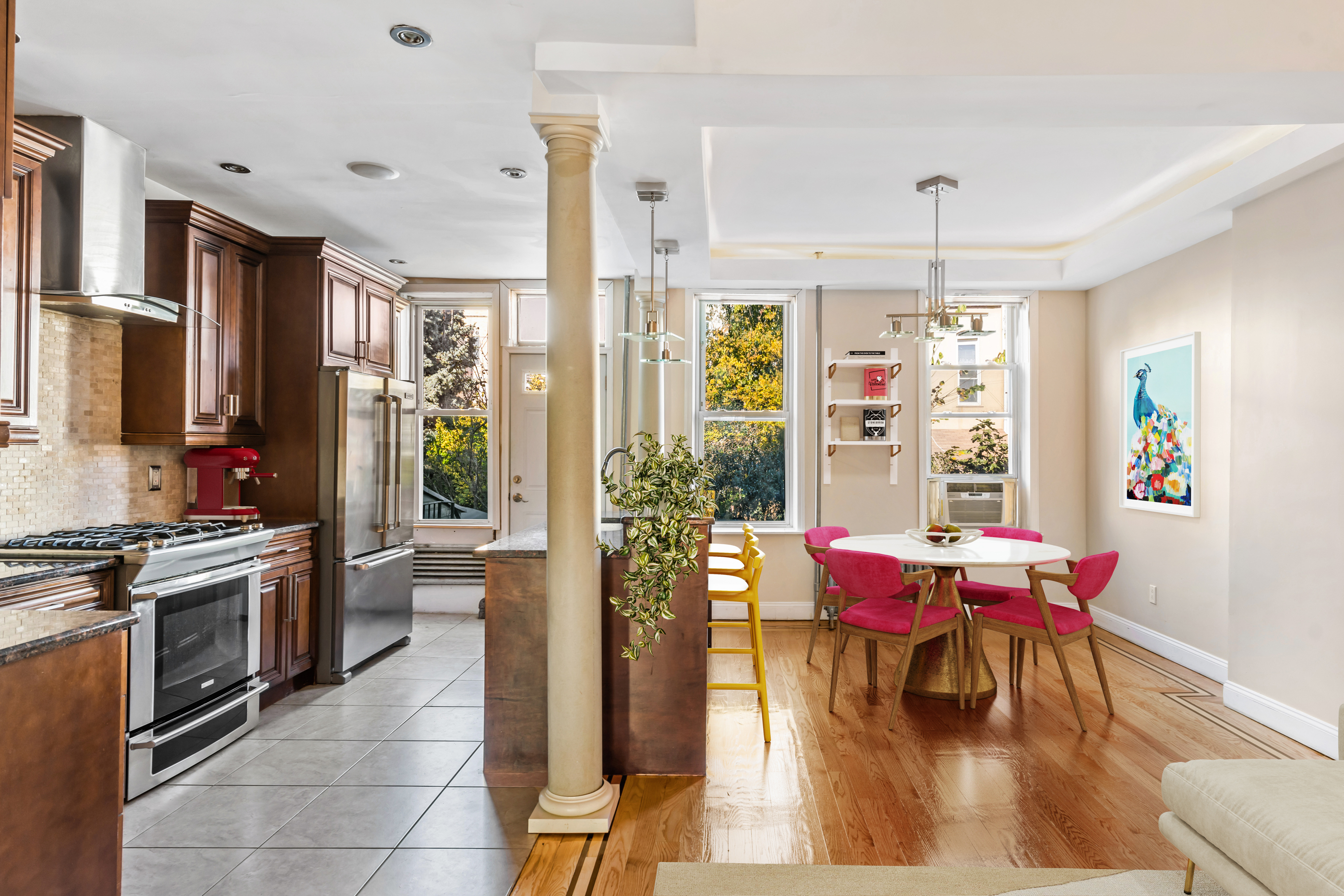 a kitchen with stainless steel appliances kitchen island granite countertop a dining table chairs and granite counter tops