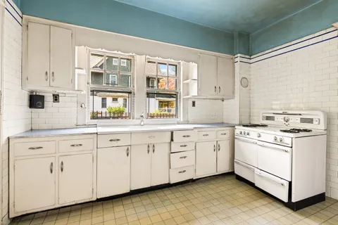 a kitchen with granite countertop white cabinets and white appliances