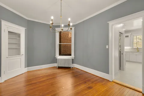 a view of a room with wooden floor staircase and a kitchen