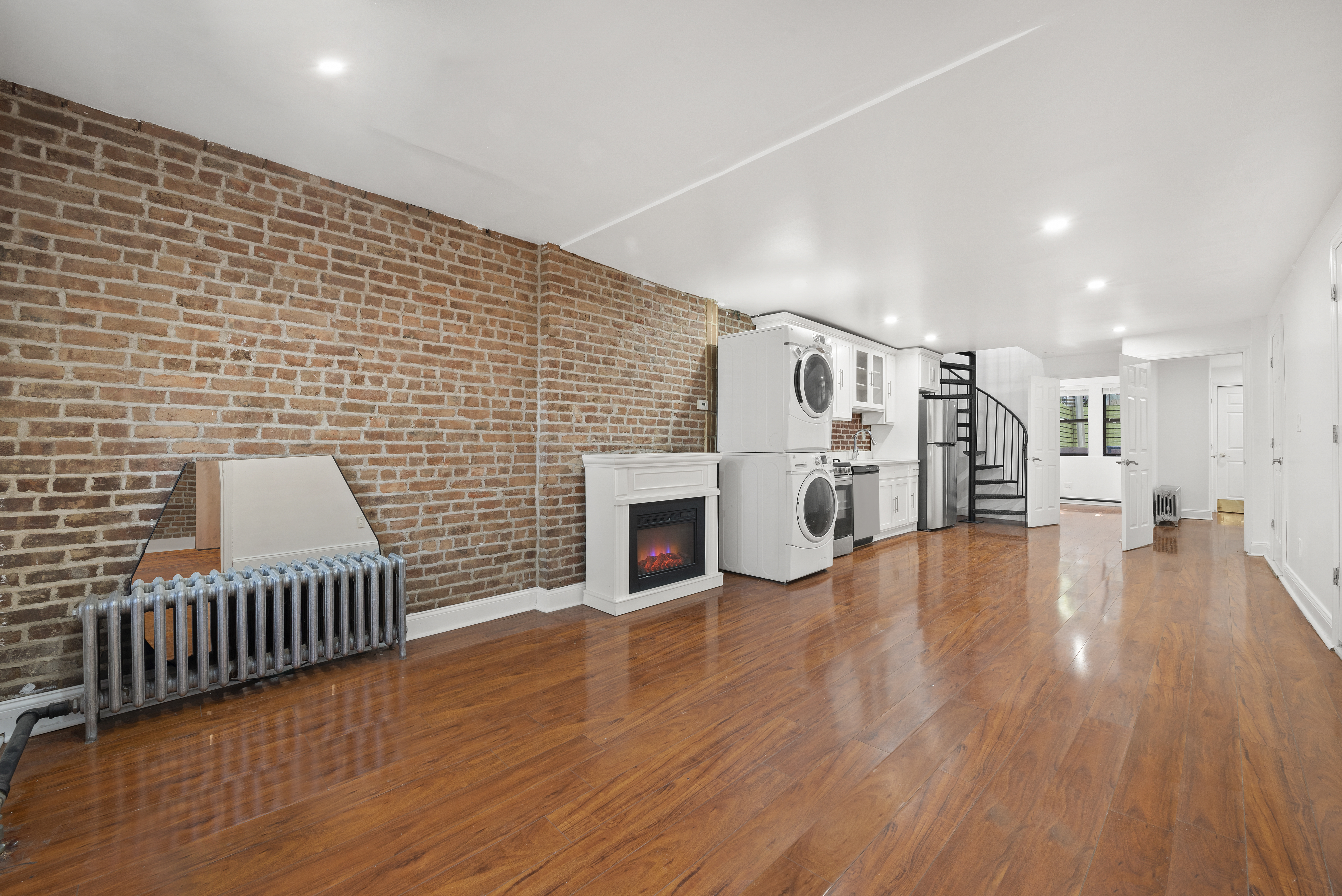 654 Lafayette Avenue, Unit GARDENA Brooklyn, NY 11216 - Photo 3 of 14 a view of empty room with wooden floor and fireplace