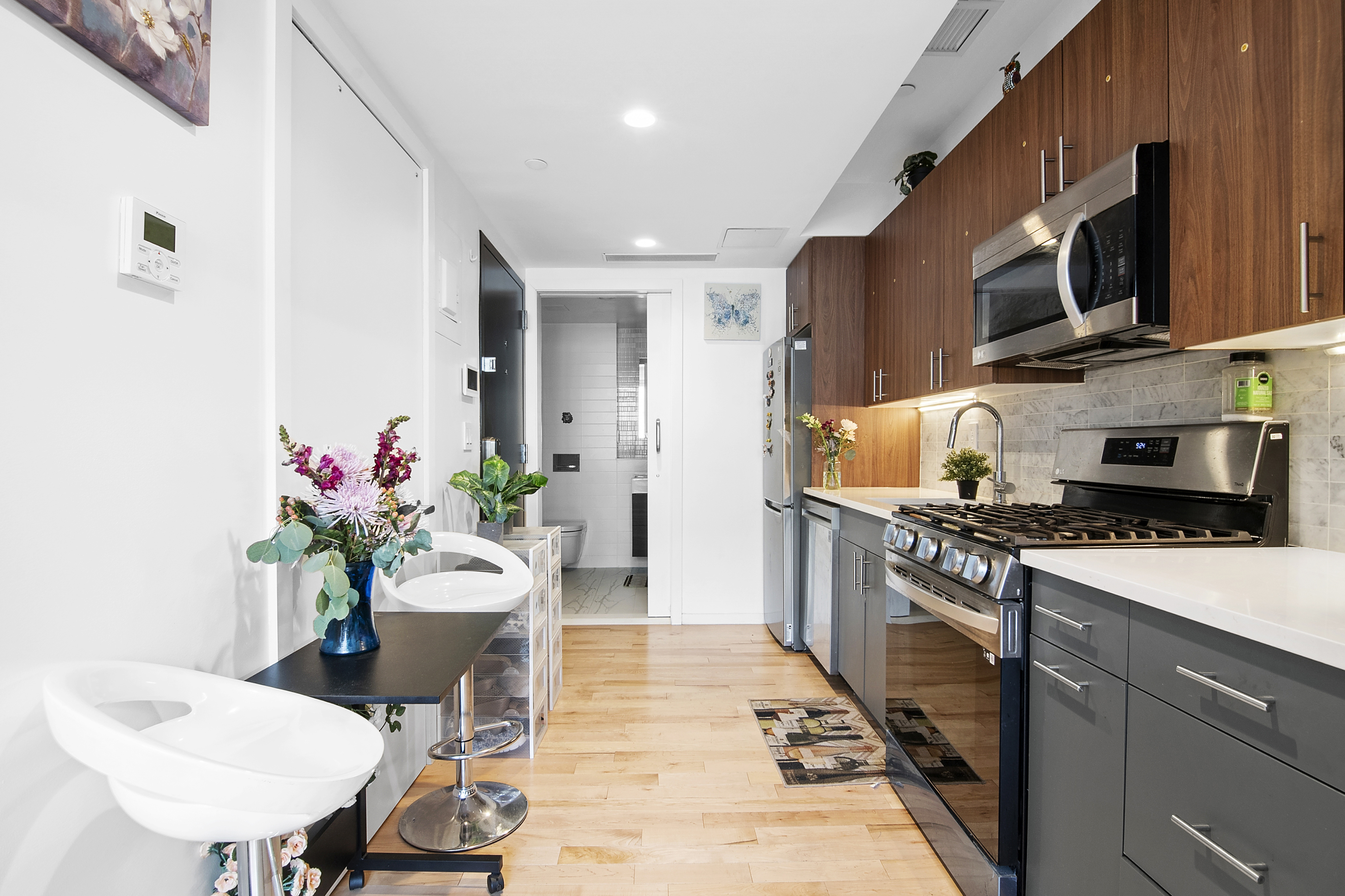 1064 Hancock Street, Unit 101 Brooklyn, NY 11221 - Photo 5 of 9 a kitchen with stainless steel appliances granite countertop a refrigerator a stove a sink dishwasher and white cabinets with wooden floor