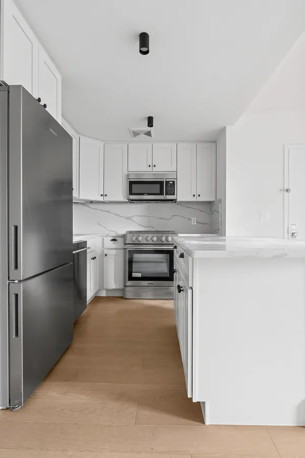 a kitchen with refrigerator a microwave and cabinets