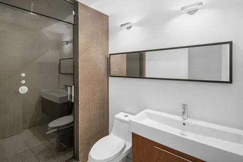 a white toilet sitting next to a bathroom sink