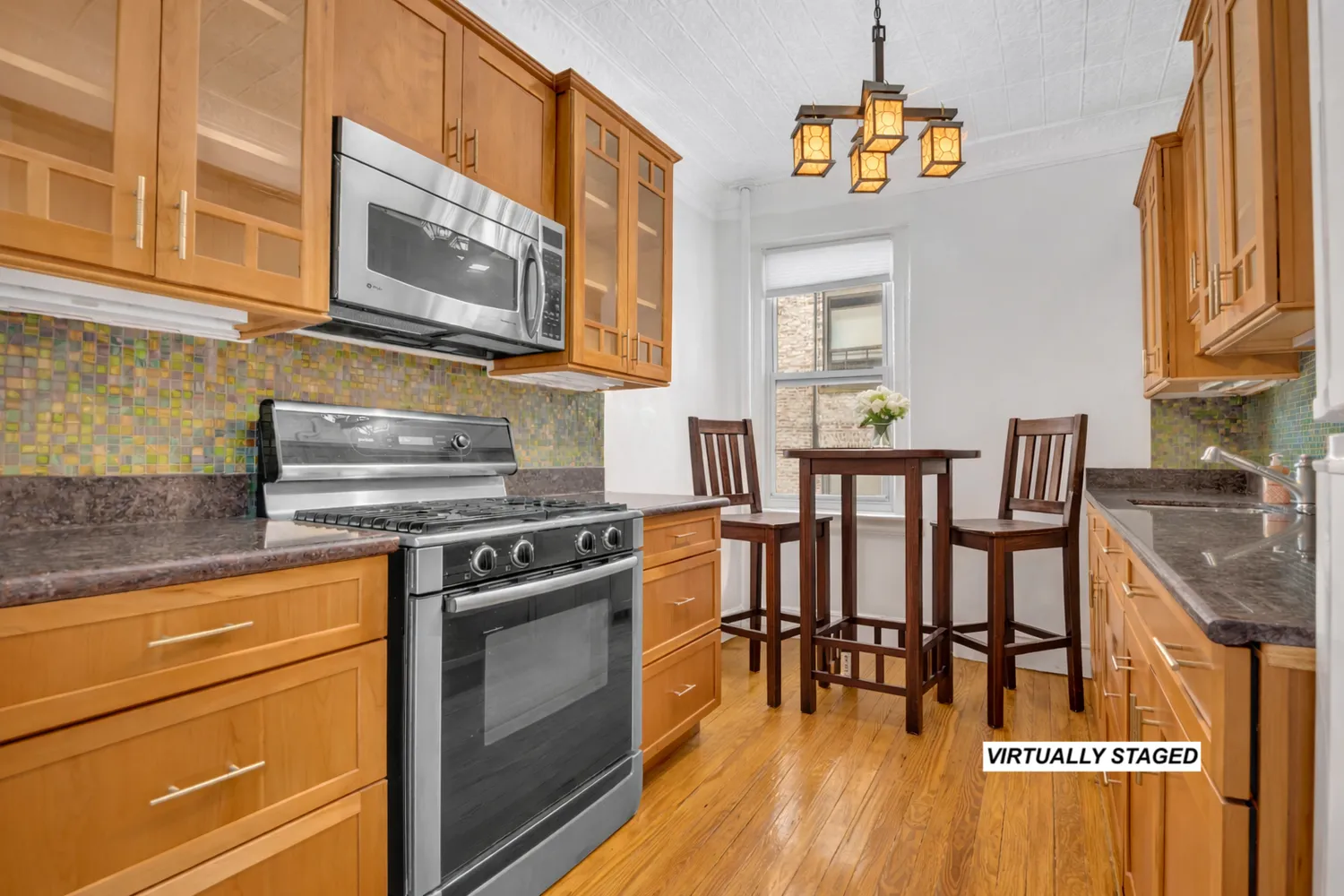 a kitchen with stainless steel appliances granite countertop a stove top oven a dining table and chairs with wooden floor