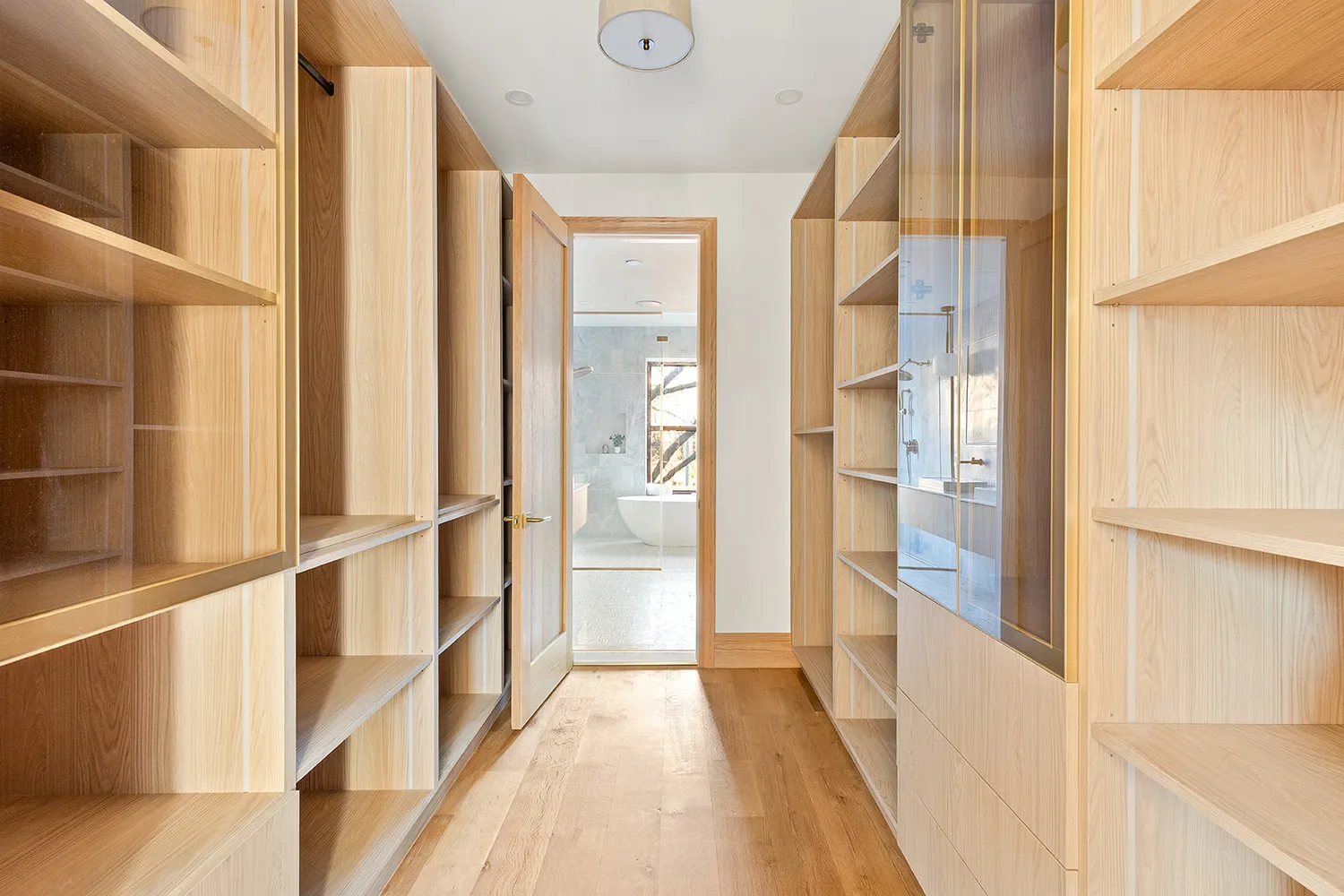a view of a hallway with wooden floor and windows