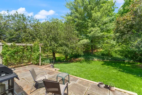 a view of backyard with seating area and green space