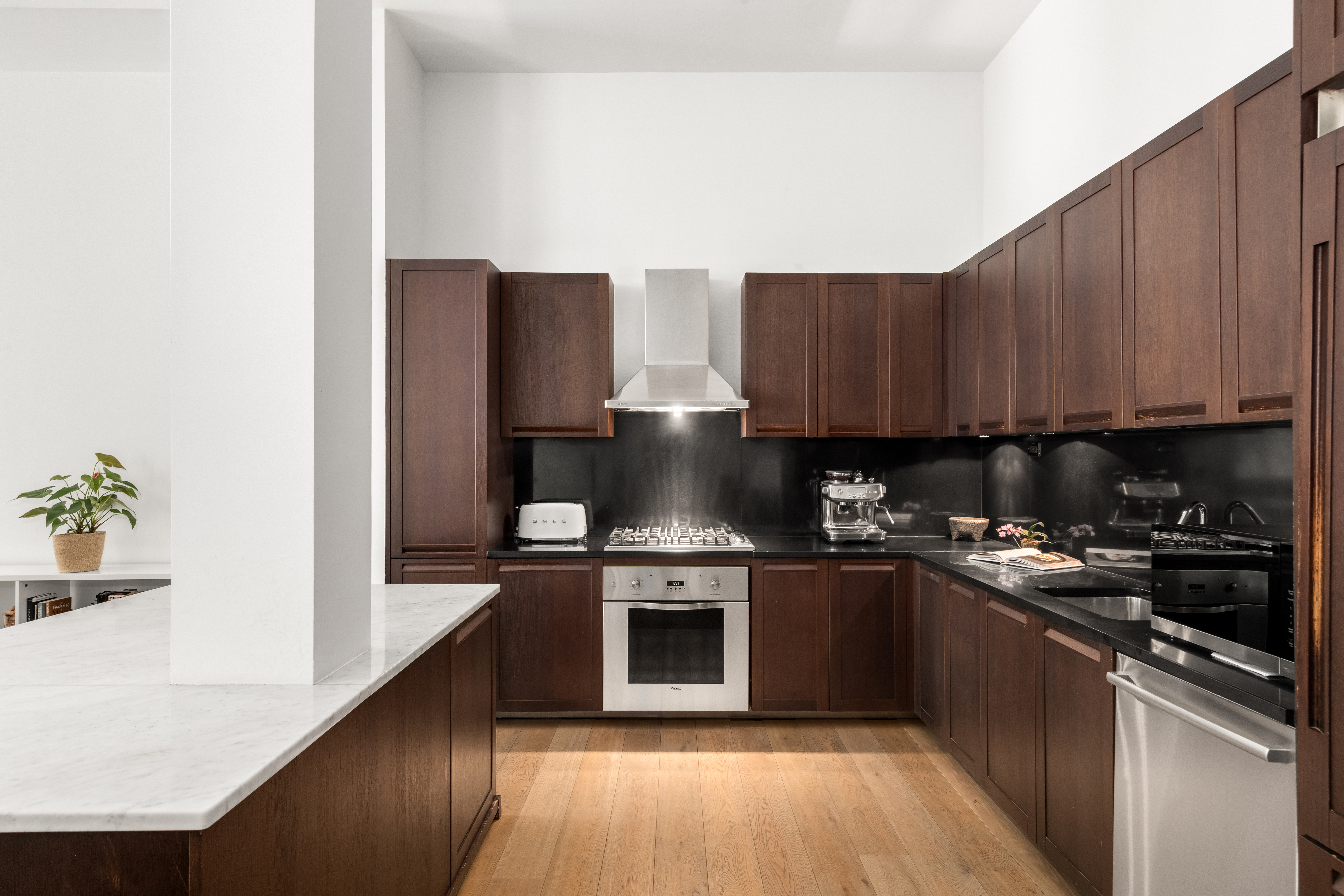 655 6th Avenue, Unit 5H Manhattan, NY 10010 - Photo 5 of 15 a kitchen with stainless steel appliances granite countertop a stove a refrigerator and a microwave
