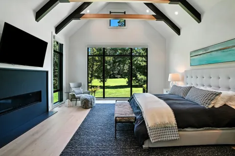 a view of a hallway with wooden floor and a living room