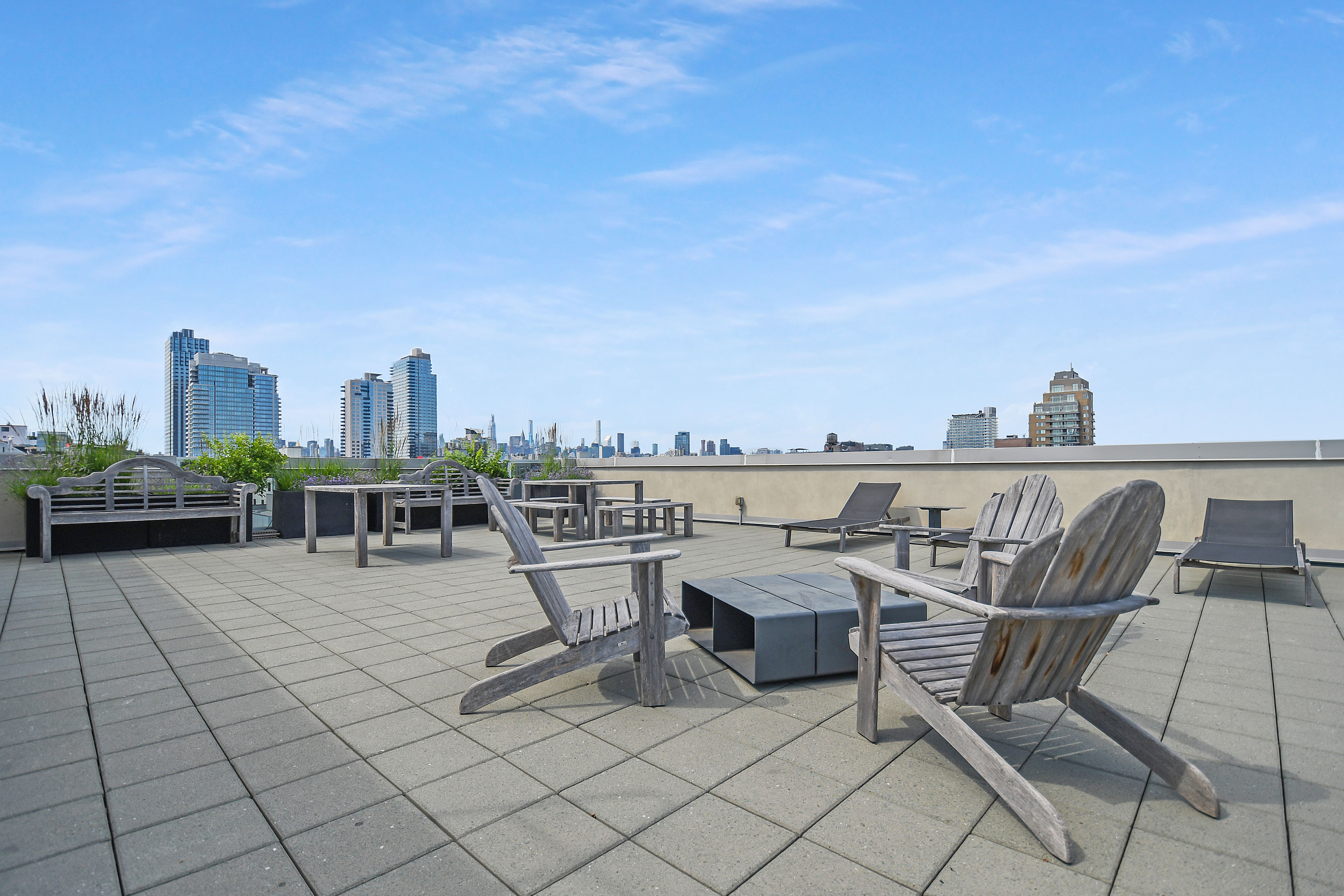 250 Bedford Avenue, Unit 129203 Brooklyn, NY 11249 - Photo 6 of 10 a roof deck with table and chairs couches with wooden floor