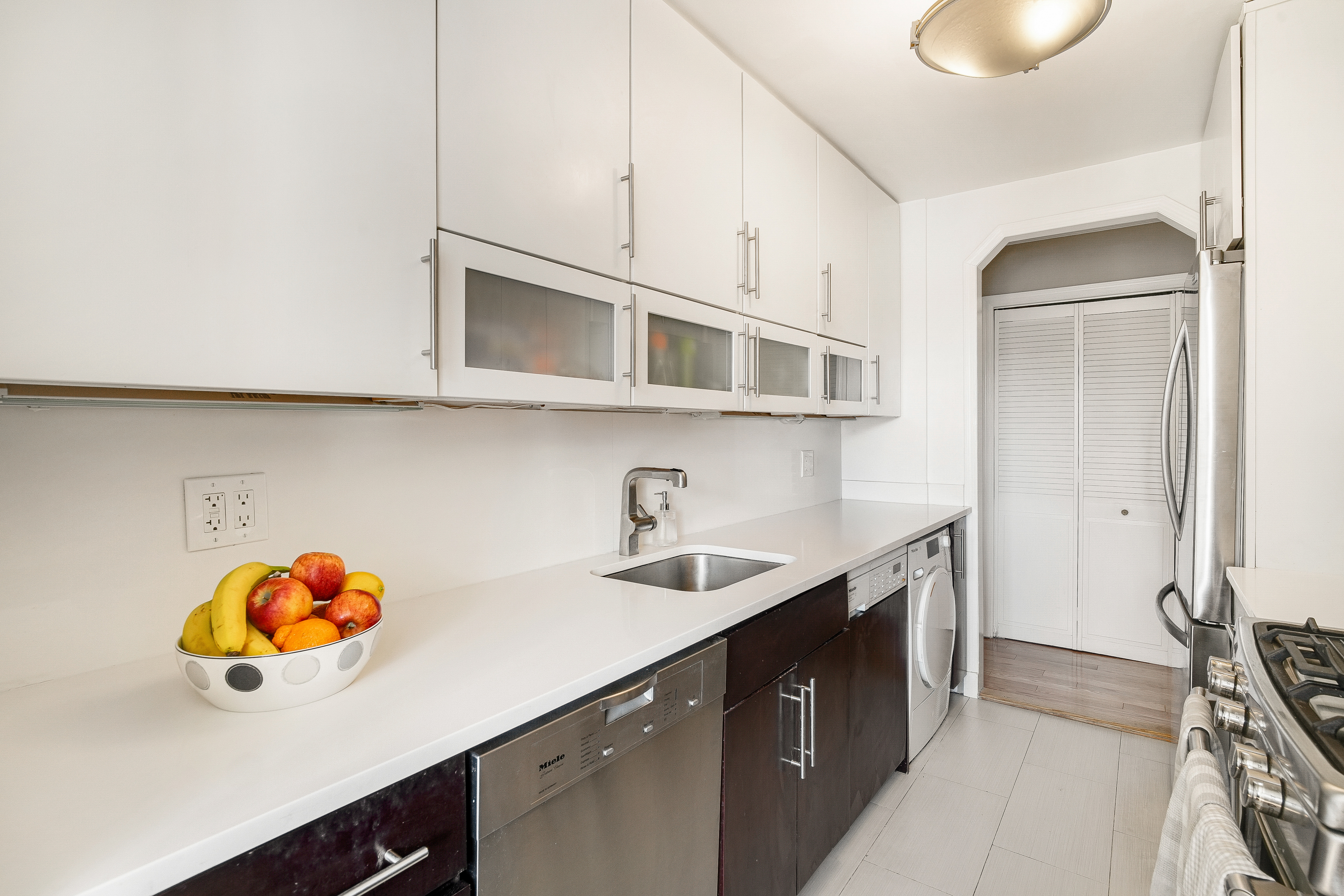 401 East 86th Street, Unit 15C Manhattan, NY 10028 - Photo 4 of 14 a kitchen with stainless steel appliances cabinets a sink and a stove