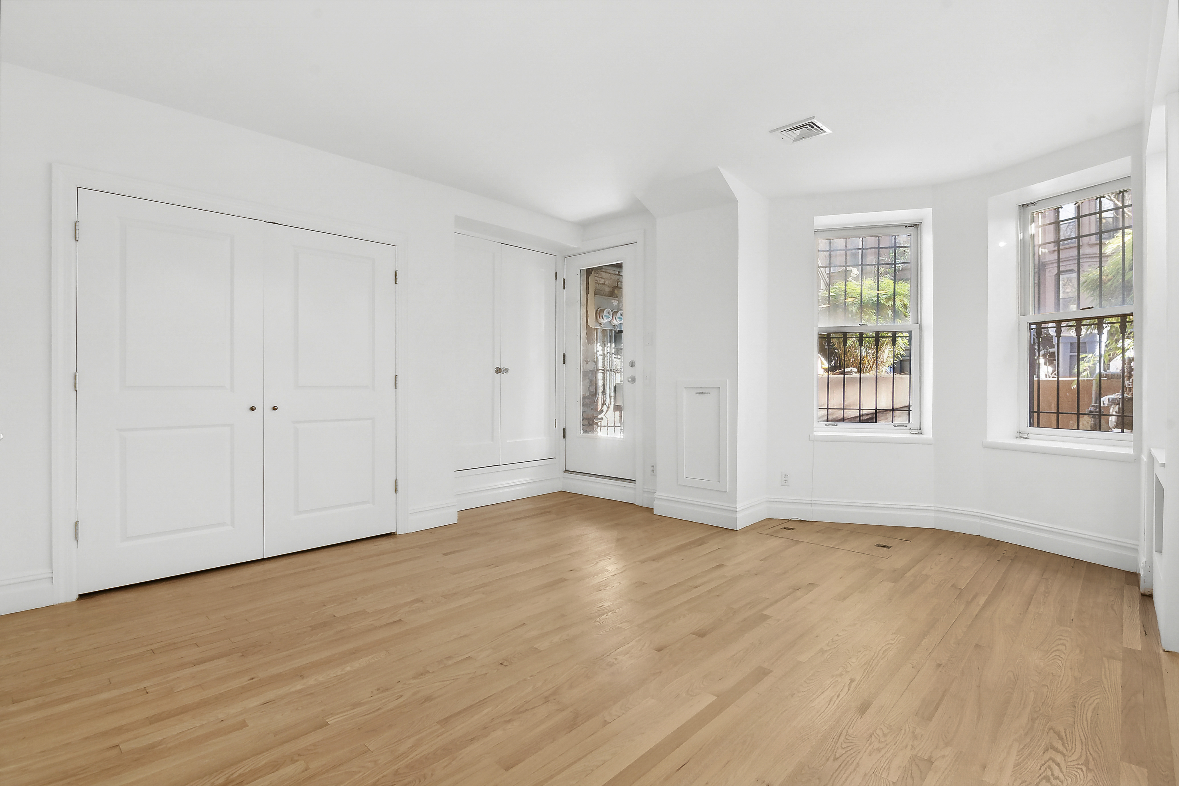 562 Washington Avenue, Unit 1 Brooklyn, NY 11238 - Photo 7 of 12 a view of an empty room with wooden floor and a window