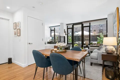 a dining room with furniture a rug and a floor to ceiling window