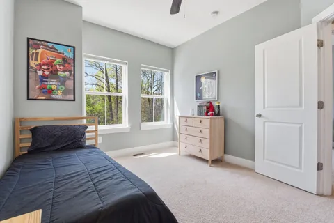 a bedroom with a bed dresser and window