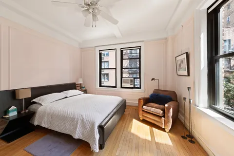 a bedroom with a bed and a couch next to a window