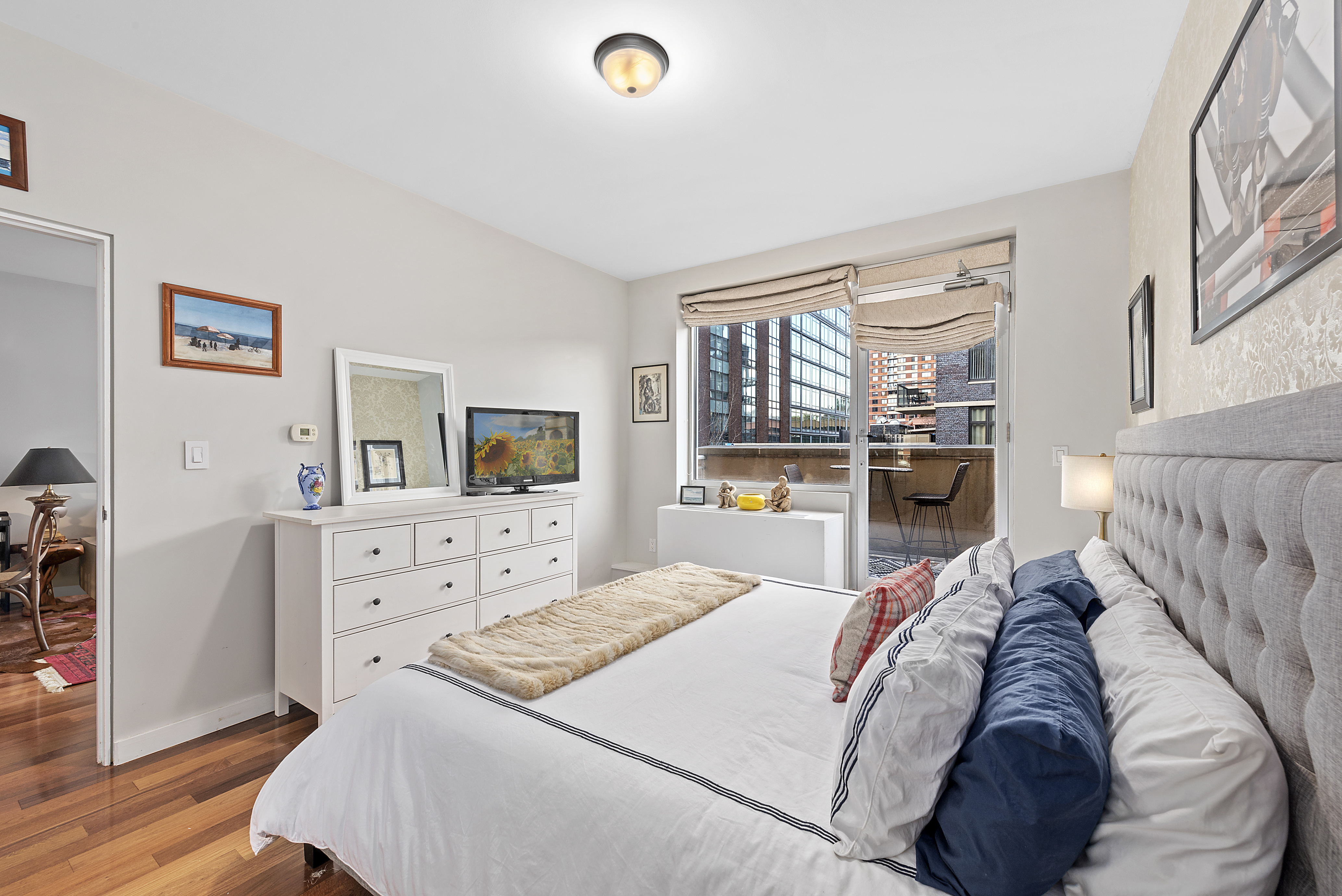 2-40 51st Avenue, Unit 2N Queens, NY 11101 - Photo 6 of 12 a bed room with a bed and a television