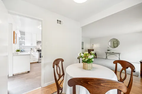 a dining room with furniture and potted plants