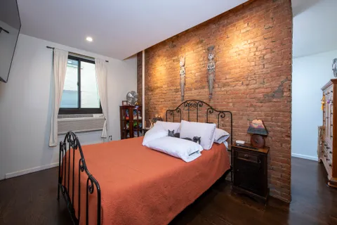 a bedroom with a bed and a large window