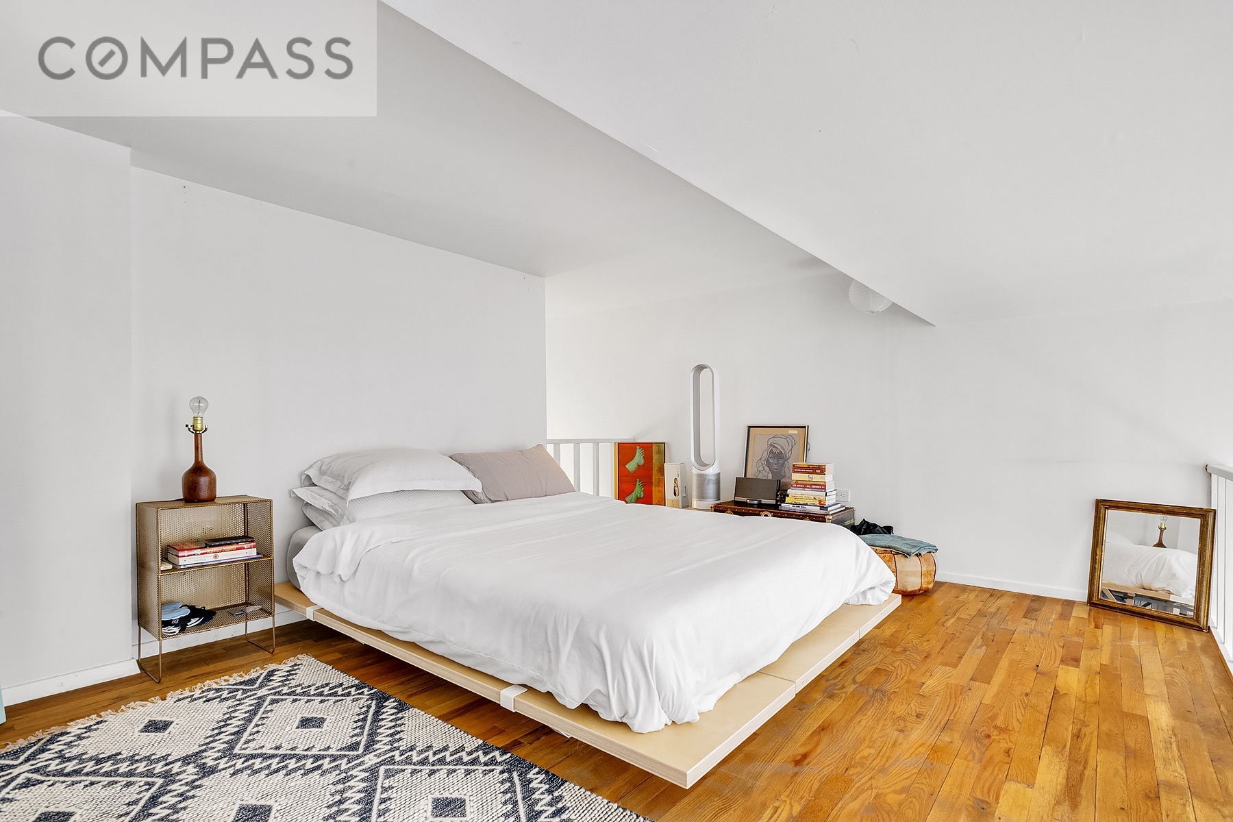 250 Mercer Street, Unit C309 Manhattan, NY 10012 - Photo 4 of 8 a bedroom with a bed and a table in it