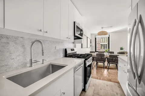 a kitchen with stainless steel appliances granite countertop a sink a stove and a refrigerator
